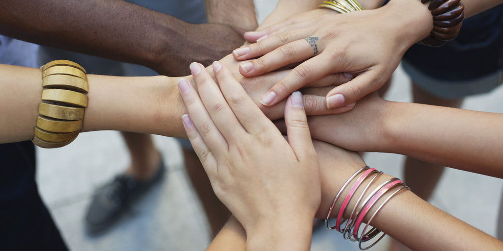 Hands of diverse women clasping in unity